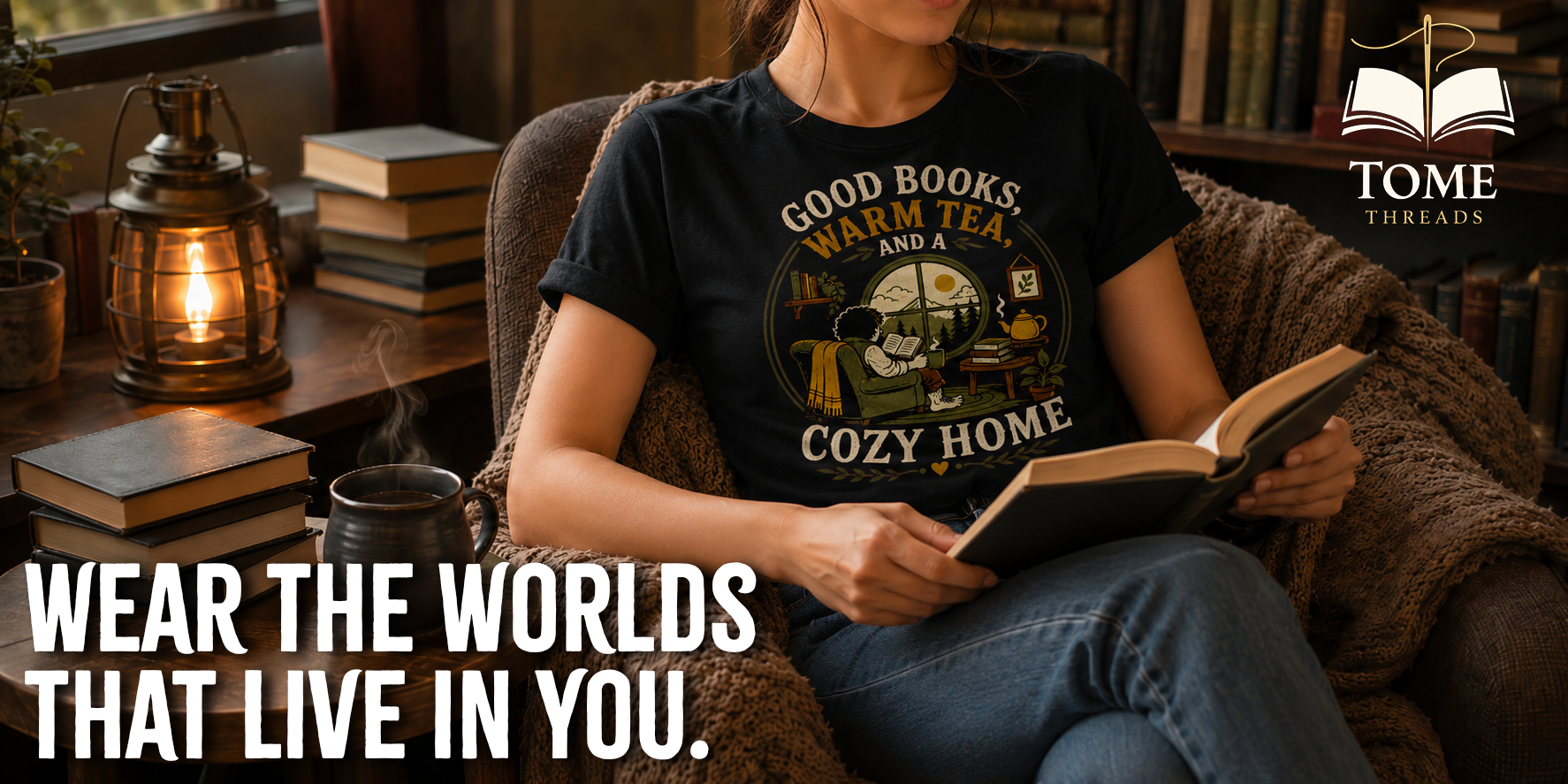 Person wearing a 'Good Books, Warm Tea, Cozy Home' t-shirt reading a book in a cozy setting with 'Tome Threads' branding.